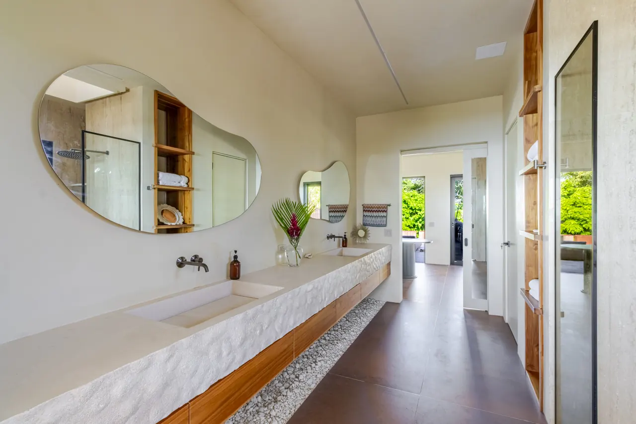 Spacious bathroom with a double vanity and doors opening to the terrace
