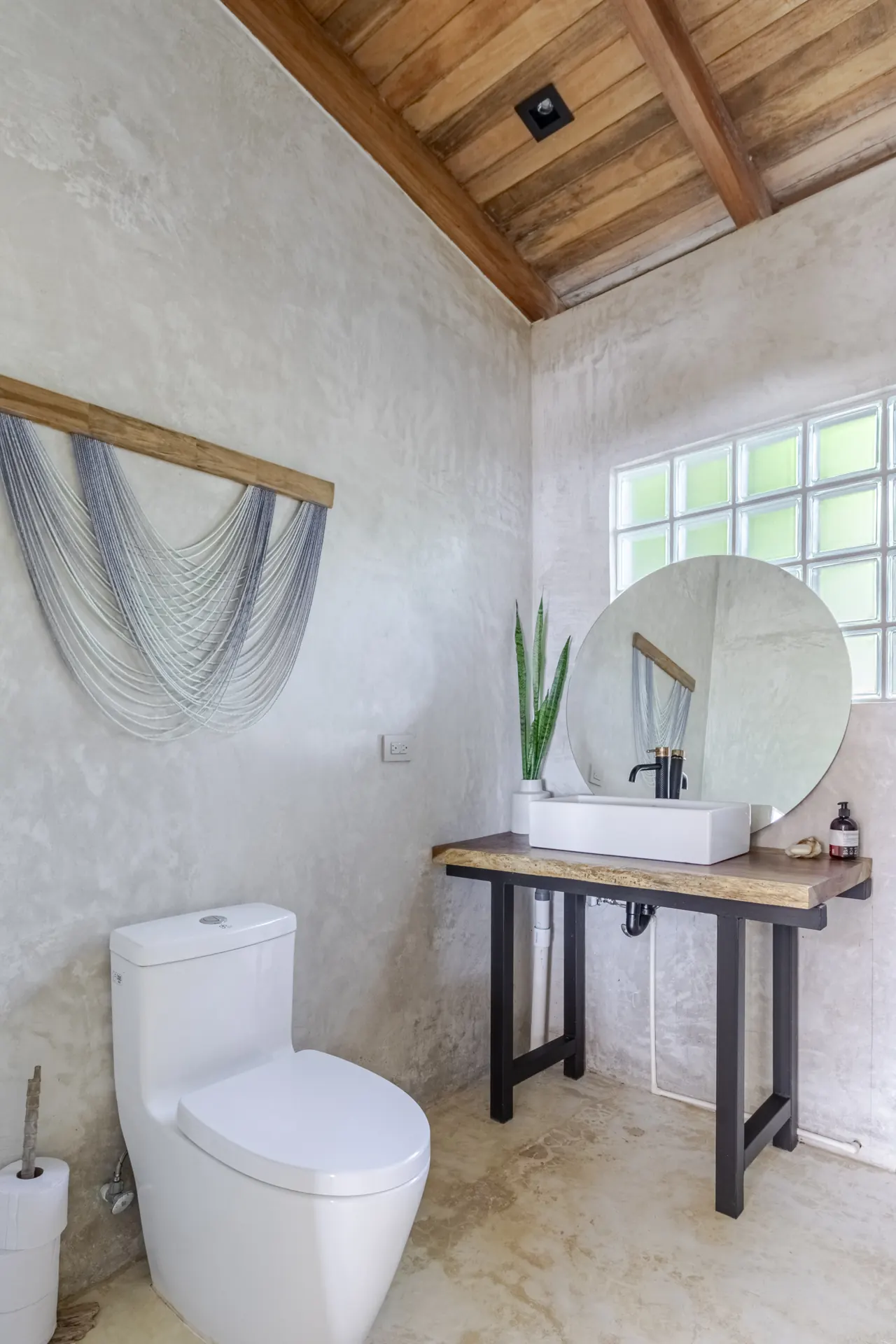 Bathroom with a round mirror, open vanity and timber ceiling