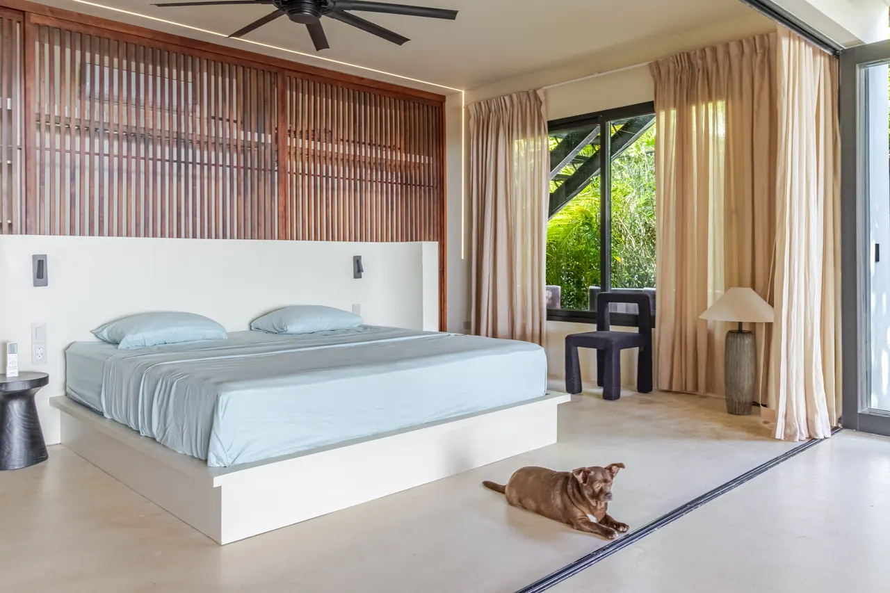 King bedroom with blue bedding, timber details and doors to the terrace