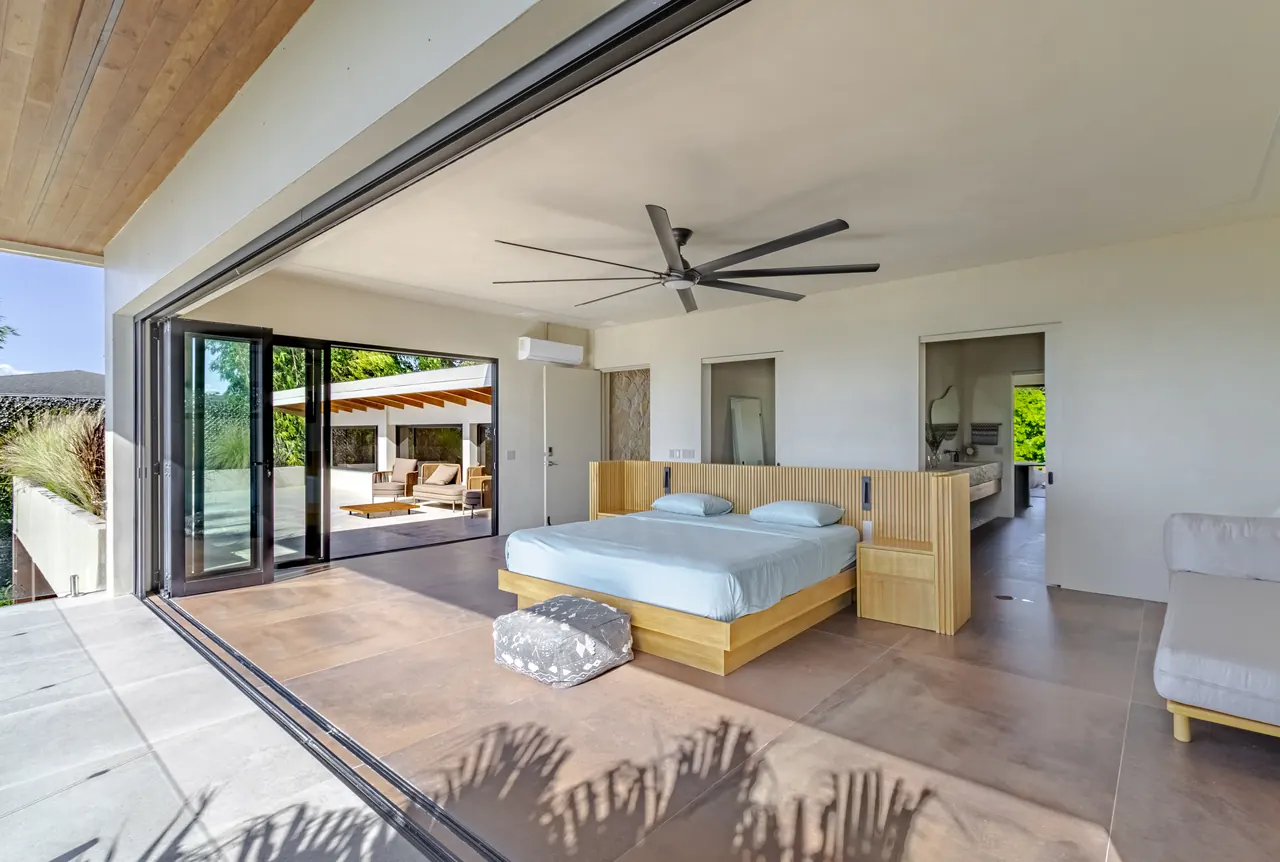 King bedroom with folding glass doors opening onto an ocean-facing terrace