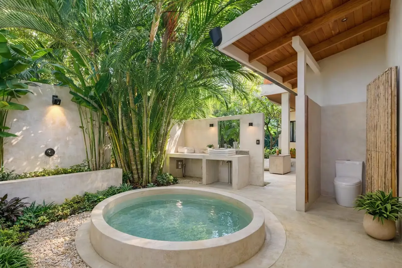 Circular soaking tub in a planted open-air bathroom courtyard