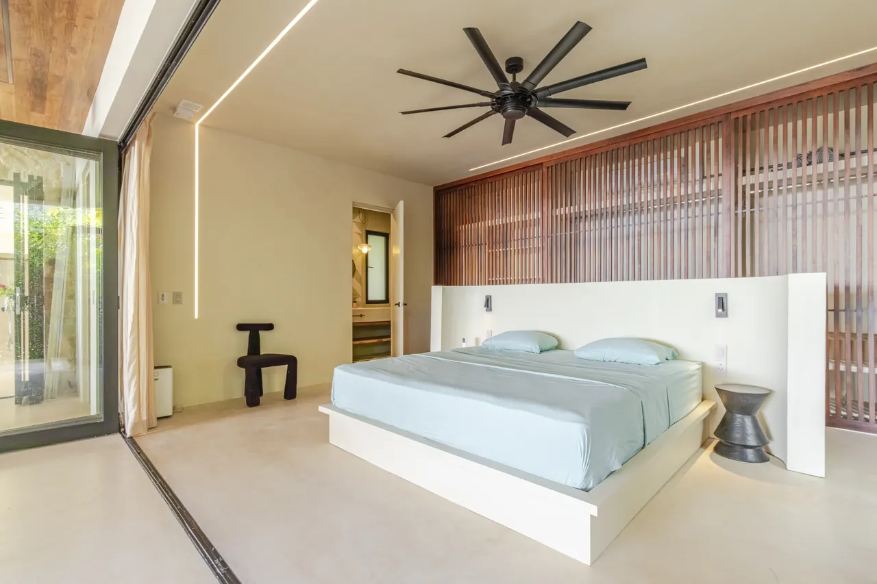 King bedroom with a slatted timber feature wall and pale blue bedding