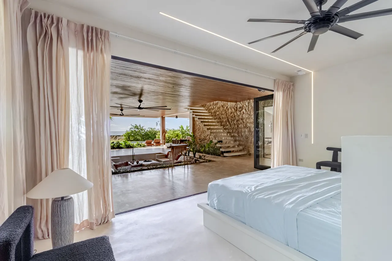 King bed beside glass doors opening onto the sunken terrace lounge