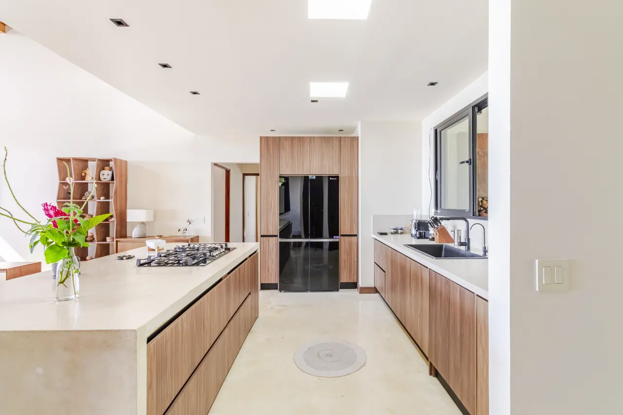 Kitchen with timber cabinets, a long island and stainless steel refrigerator