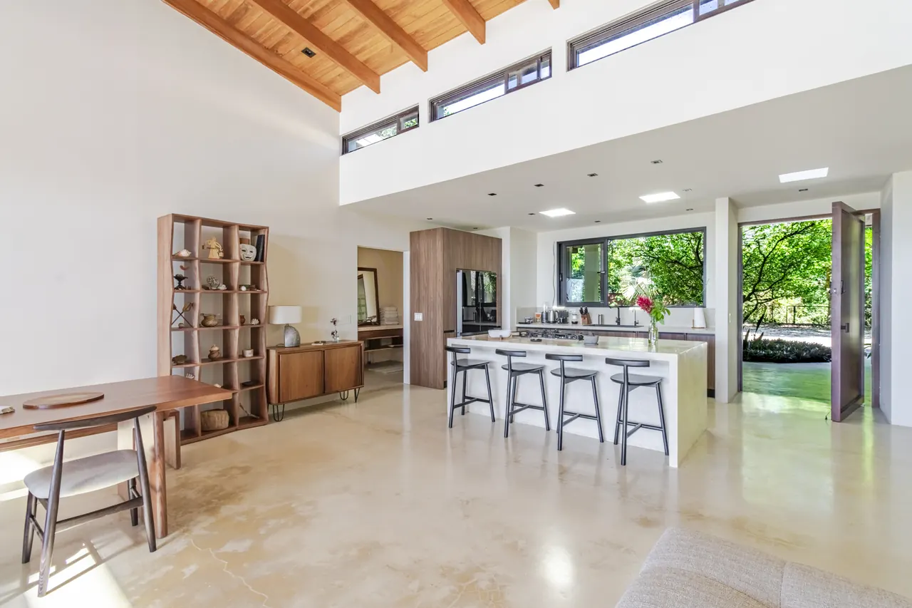 Open kitchen and dining area beneath a bright double-height ceiling