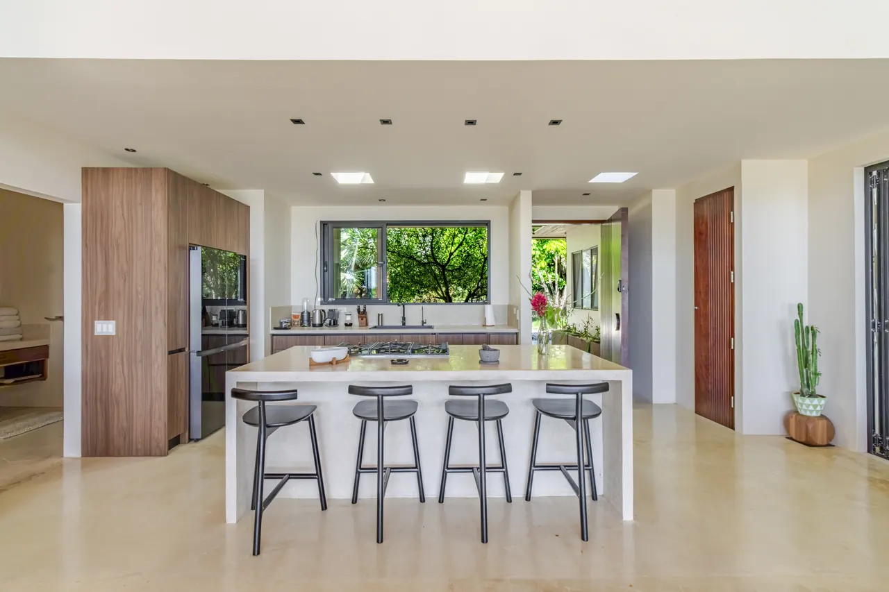 Kitchen island with three bar stools and garden-facing windows