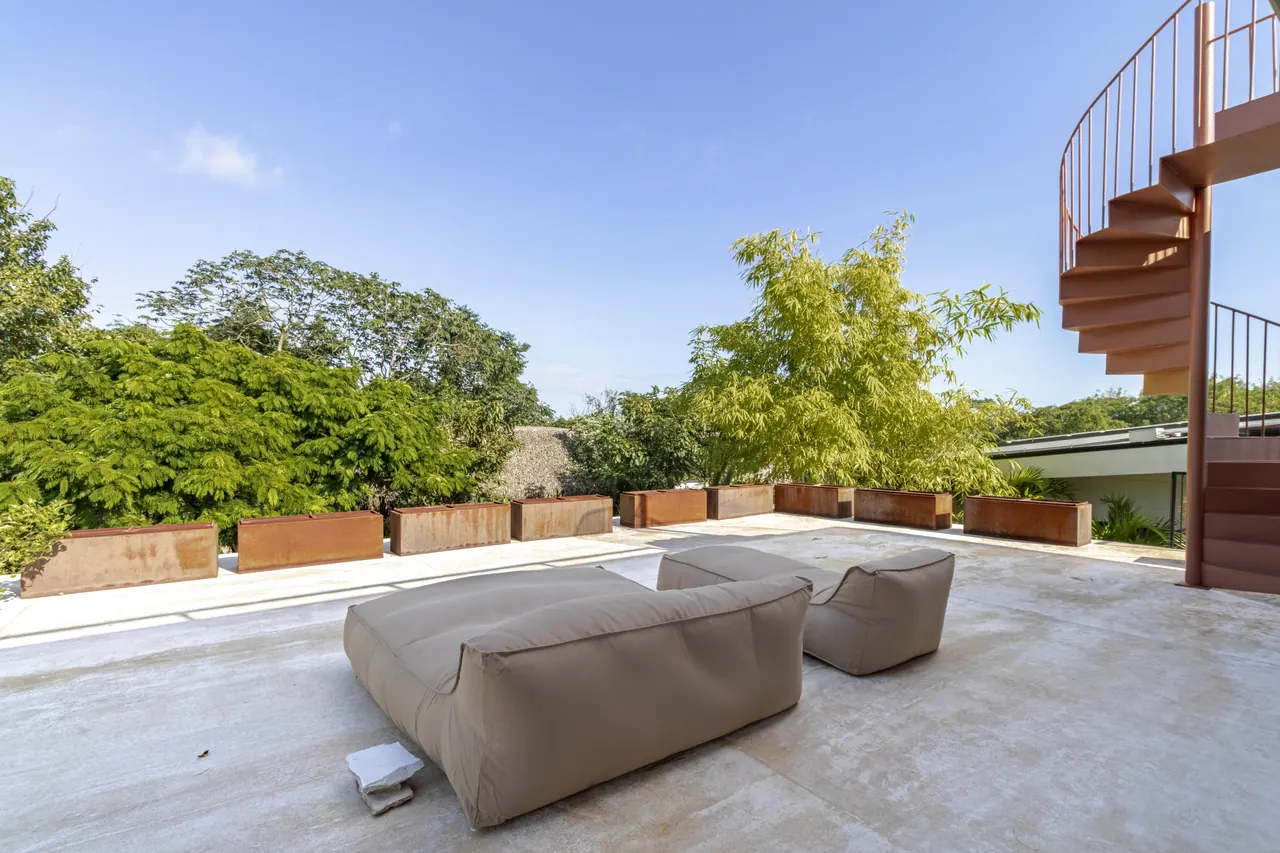 Upper terrace seating with treetop views beside the spiral staircase