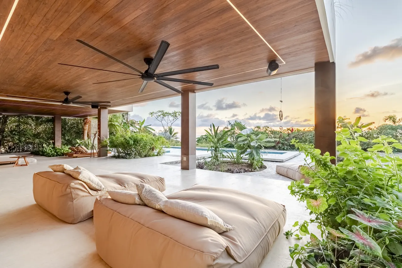 Shaded terrace seating overlooking the pool at sunset