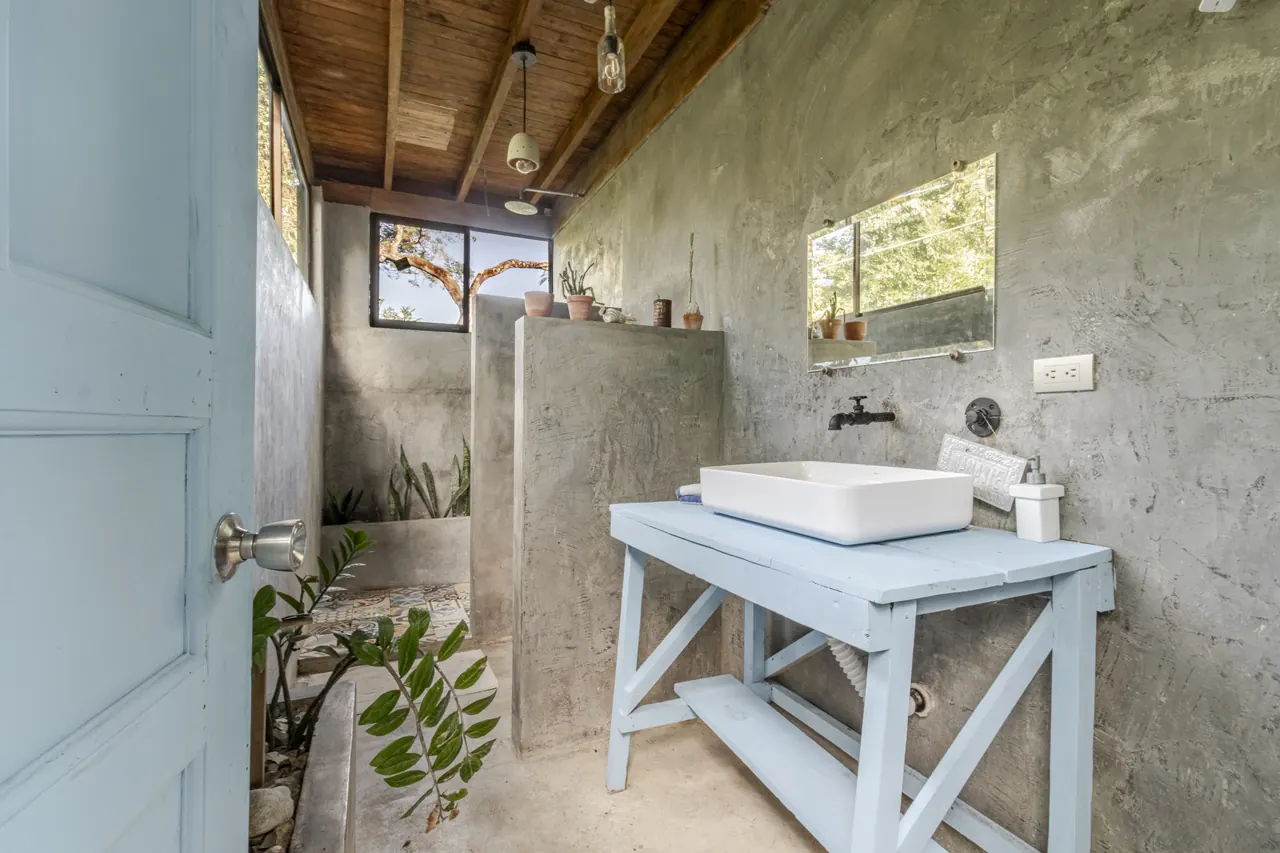 Surf Shack bathroom with a white basin, blue timber vanity and open shower