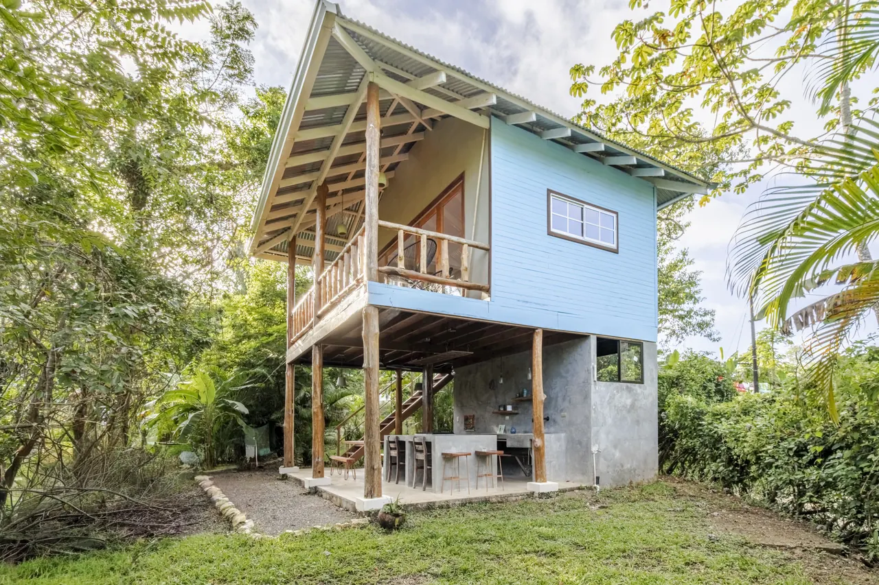 Two-level Surf Shack guest house with a balcony among tropical trees