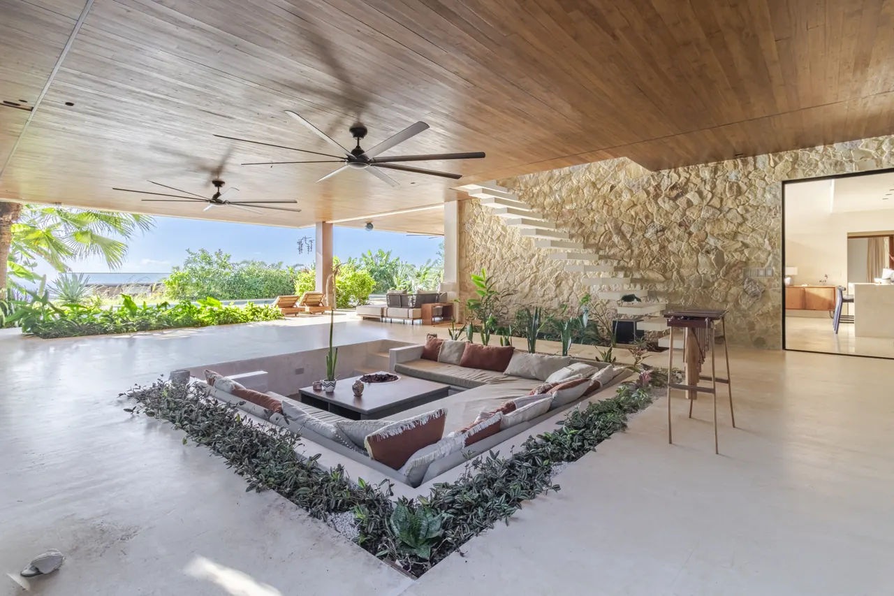 Sunken terrace lounge beside a natural stone wall and timber ceiling