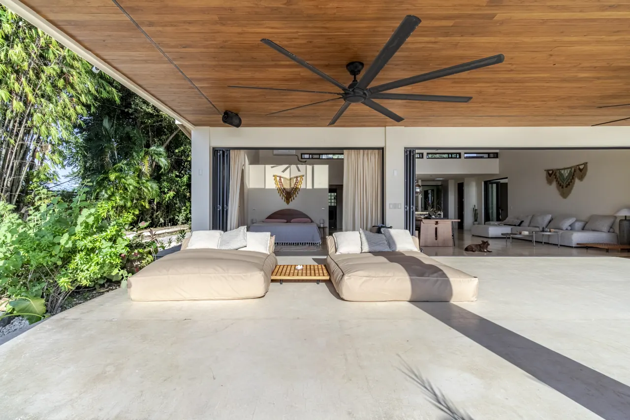Two cushioned daybeds on the covered terrace outside the bedrooms