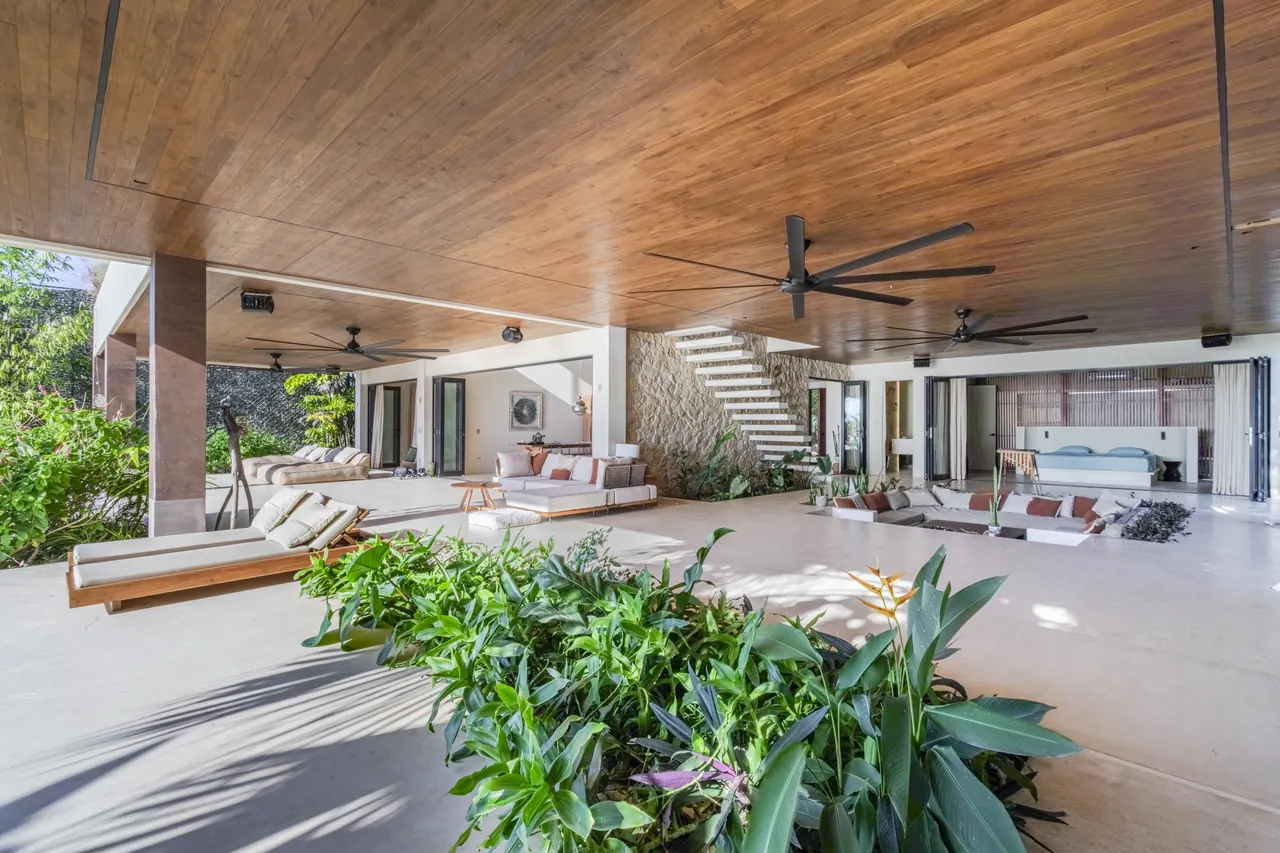 Terrace lounge framed by flowering tropical plants and open living areas