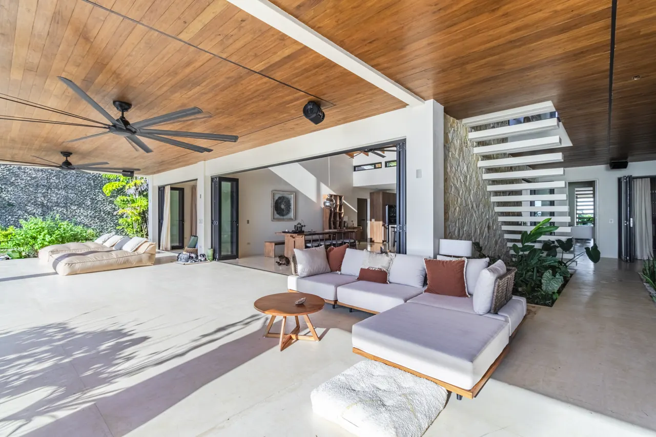 Covered outdoor lounge with a sectional sofa and timber ceiling