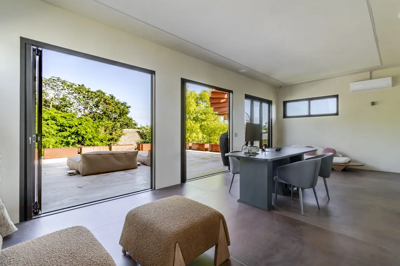Workspace with a large desk and wide doors opening to an outdoor lounge